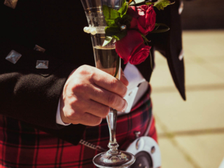 A groom holding a glass of champagne