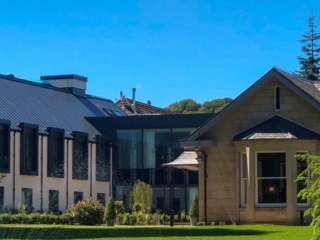 Exterior of the hotel with blue skies and green grass