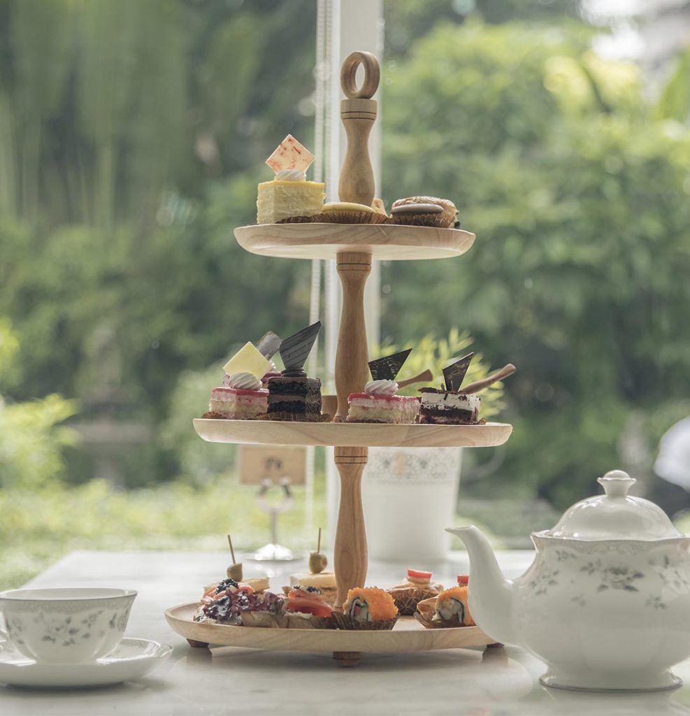 A heavenly afternoon tea with a cake tier and a pot of tea.
