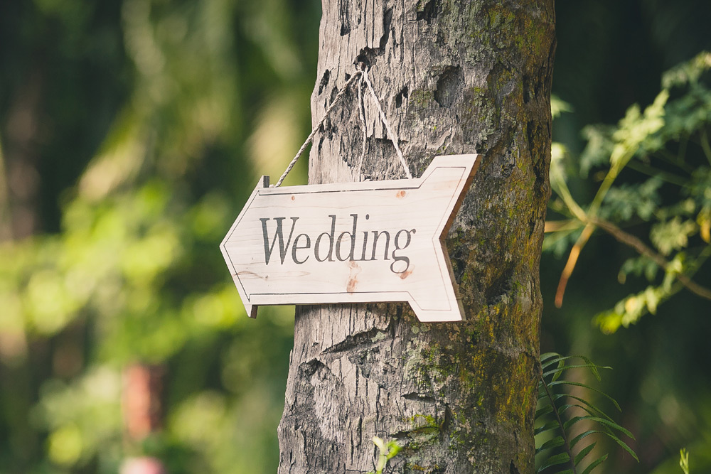 Vintage wedding sign hung up on a tree