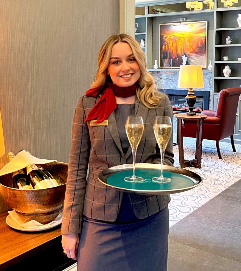 Staff member with Champagne glasses on a tray at Ness Walk Hotel