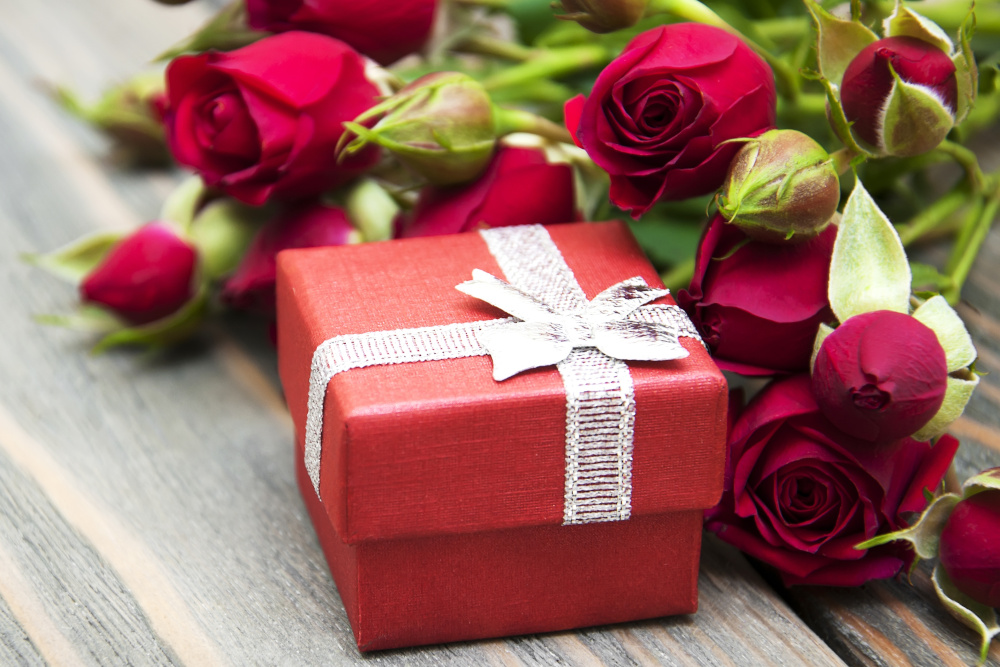 Red roses and a gift in a red box