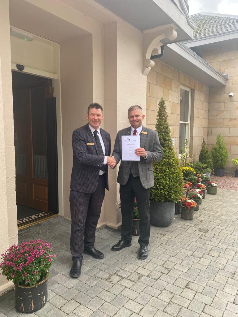 Craig Ewan awarding Mark Ford Associate of the Month outside Ness Walk Reception
