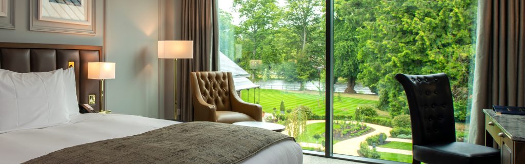 A King Oak Bedroom at Ness Walk in Inverness with view towards green gardens and River Ness beyond from floor to ceiling windows