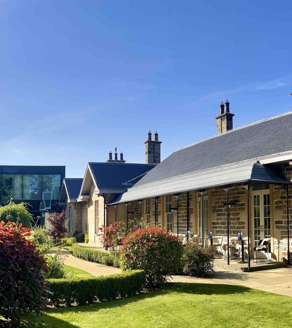 Ness Walk Courtyard on a sunny day with blue skies and vibrant green plants