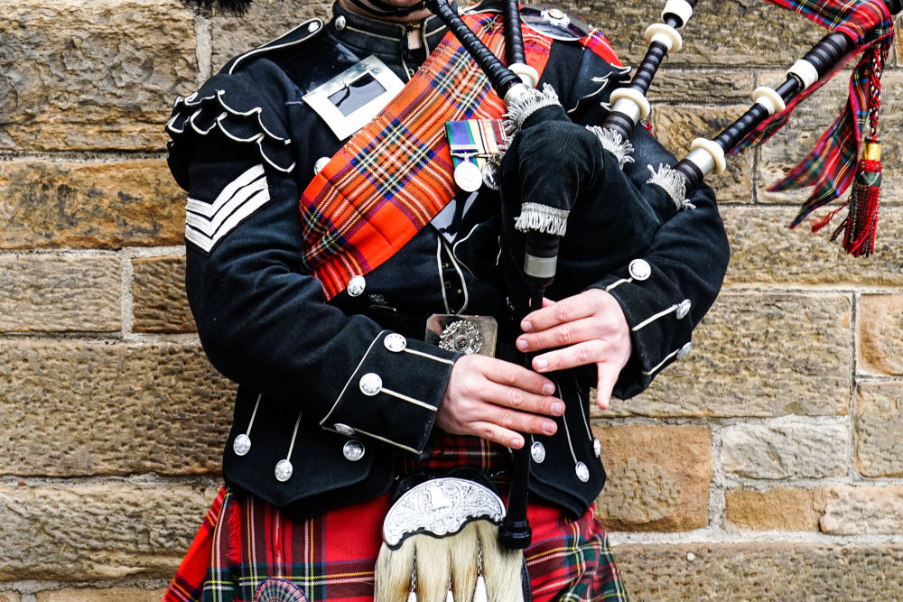 Bagpiper in Scotland wearing Highland dress