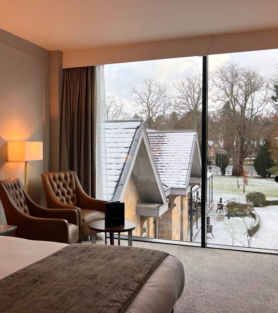 Oak King Room at Ness Walk in the winter with floor to ceiling windows overlooking a snowy riverside