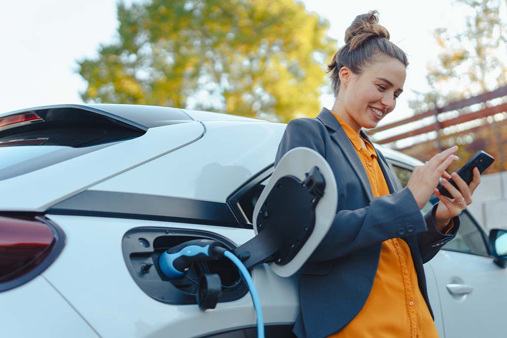 a lady charging her electric car.