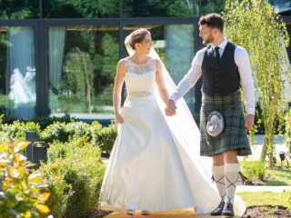 Bride and Groom holding hands in the gardens at Ness Walk Hotel.