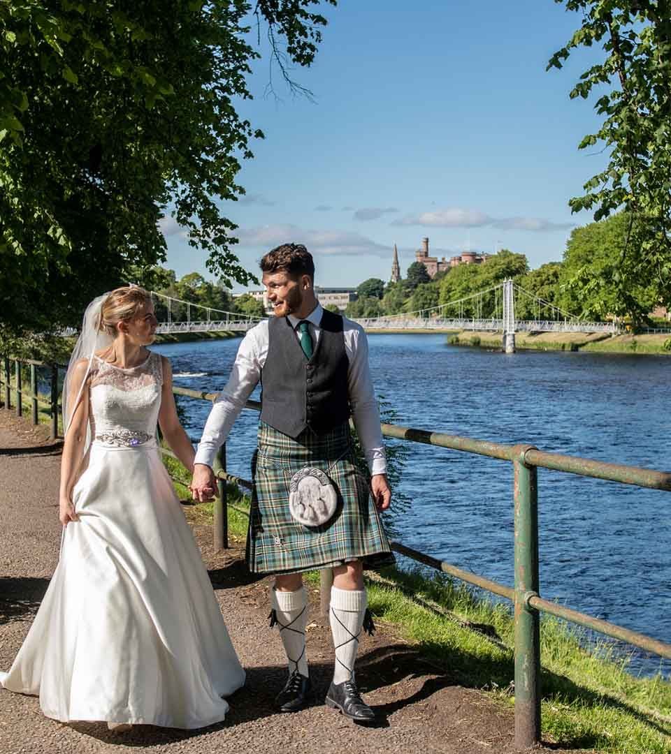 Bride and Groom walking along the River Ness at Ness Walk Hotel. Bride and Groom walking along the River Ness at Ness Walk Hotel.