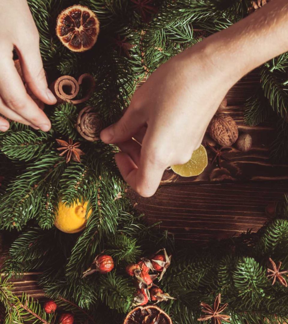 Person putting final decoration on a wreath at Ness Walk