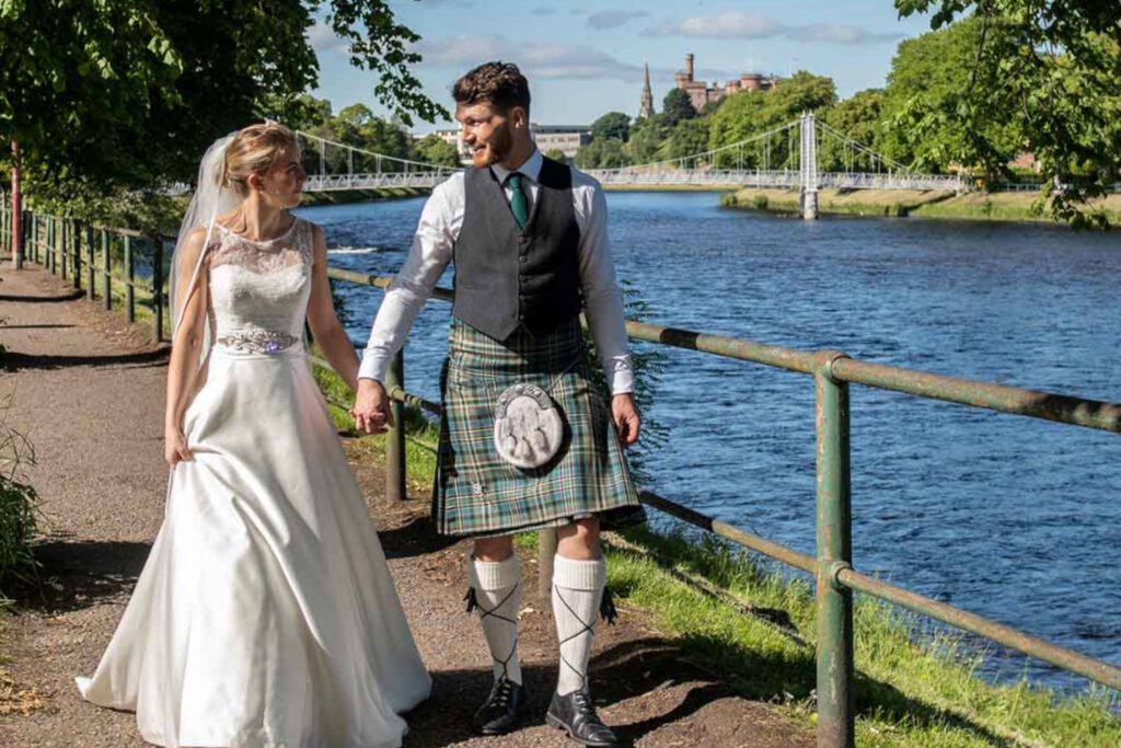 Wedding couple strolling on the banks of the River Ness