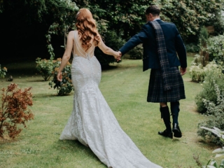 A Scottish wedding photo with our bride and groom walking in the Ness Walk Hotel Gardens in Autumn.