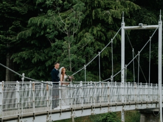 A Scottish wedding photo with a bride and groom standing on a famous Inverness bridge over the River Ness just outside our Scottish hotel.