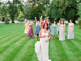 A bride throws her bouquet in the gardens on the manicured lawn at Ness Walk Hotel on the banks of the River Ness in Inverness.