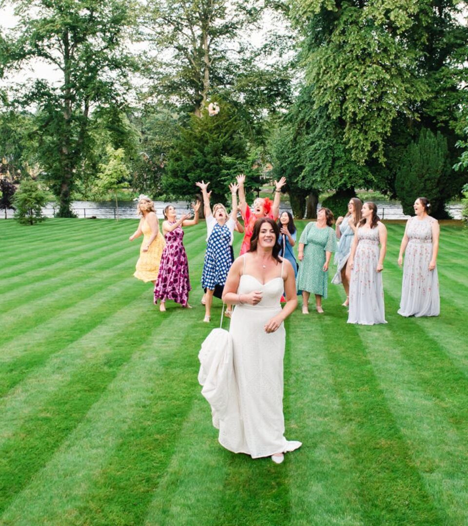 A bride throws her bouquet in the gardens on the manicured lawn at Ness Walk Hotel on the banks of the River Ness in Inverness.