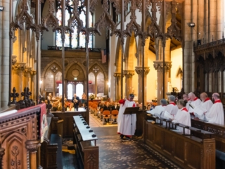 The choir at Inverness Cathedral at a traditional Scottish wedding whilst the bride signs the register.