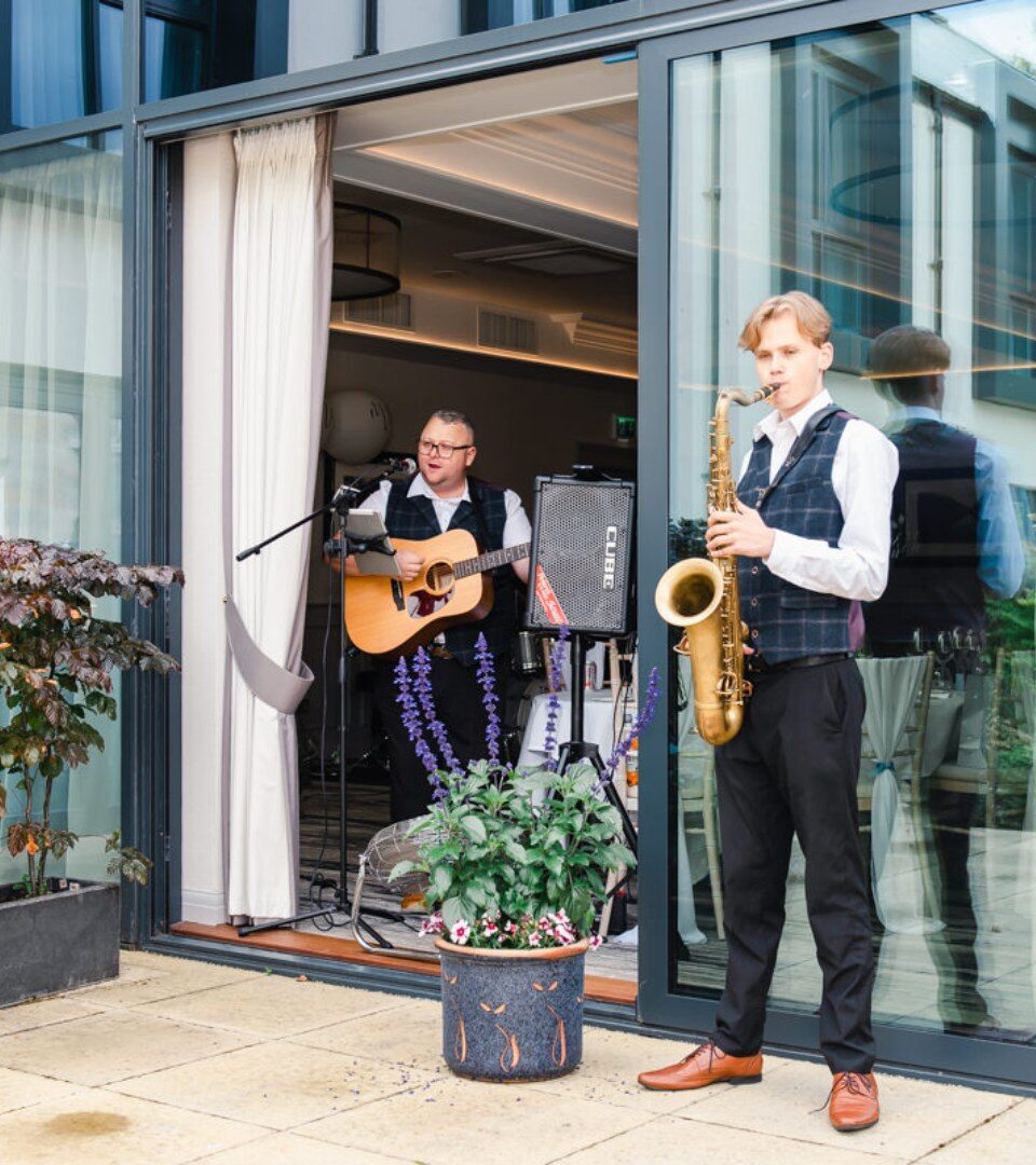 Wedding entertainers play music to Scottish wedding guests on the garden terrace at Ness Walk Hotel.