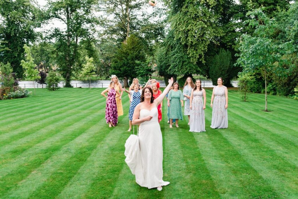 Bride throws bouquet on Ness Walk lawns at Wedding - credit Karen Thorburn
