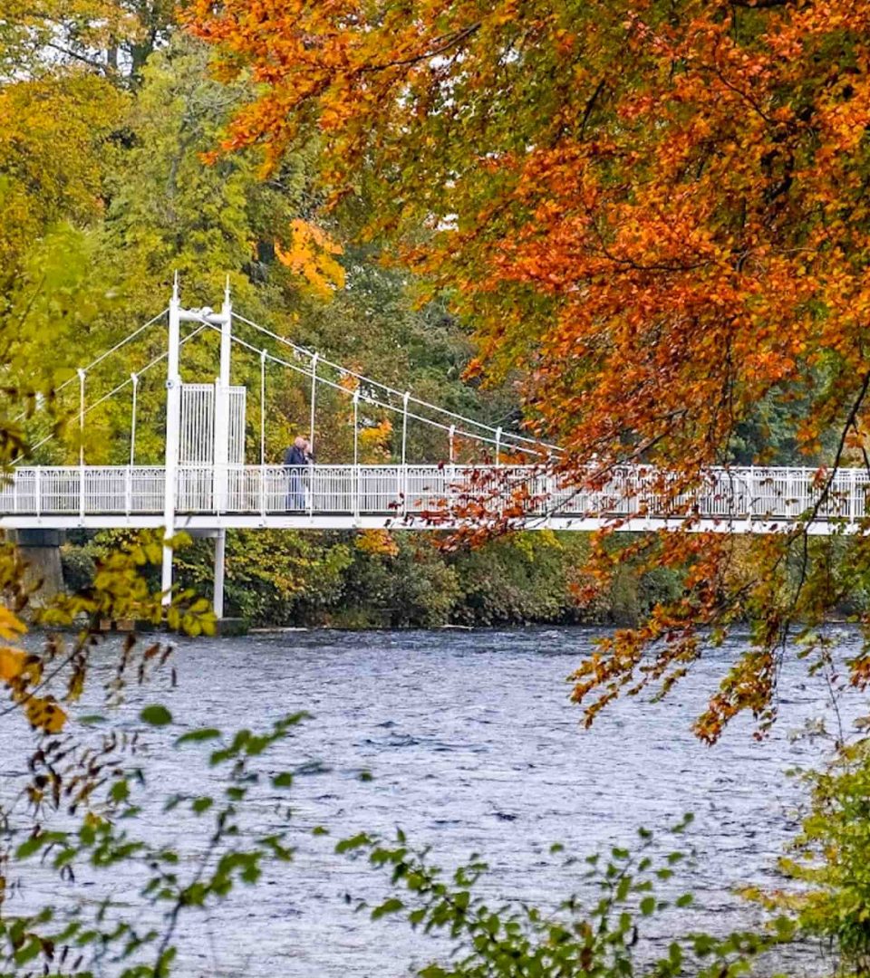 Autumn on Ness Walk overlooking the footbridges and Ness Islands with red and golden leaves