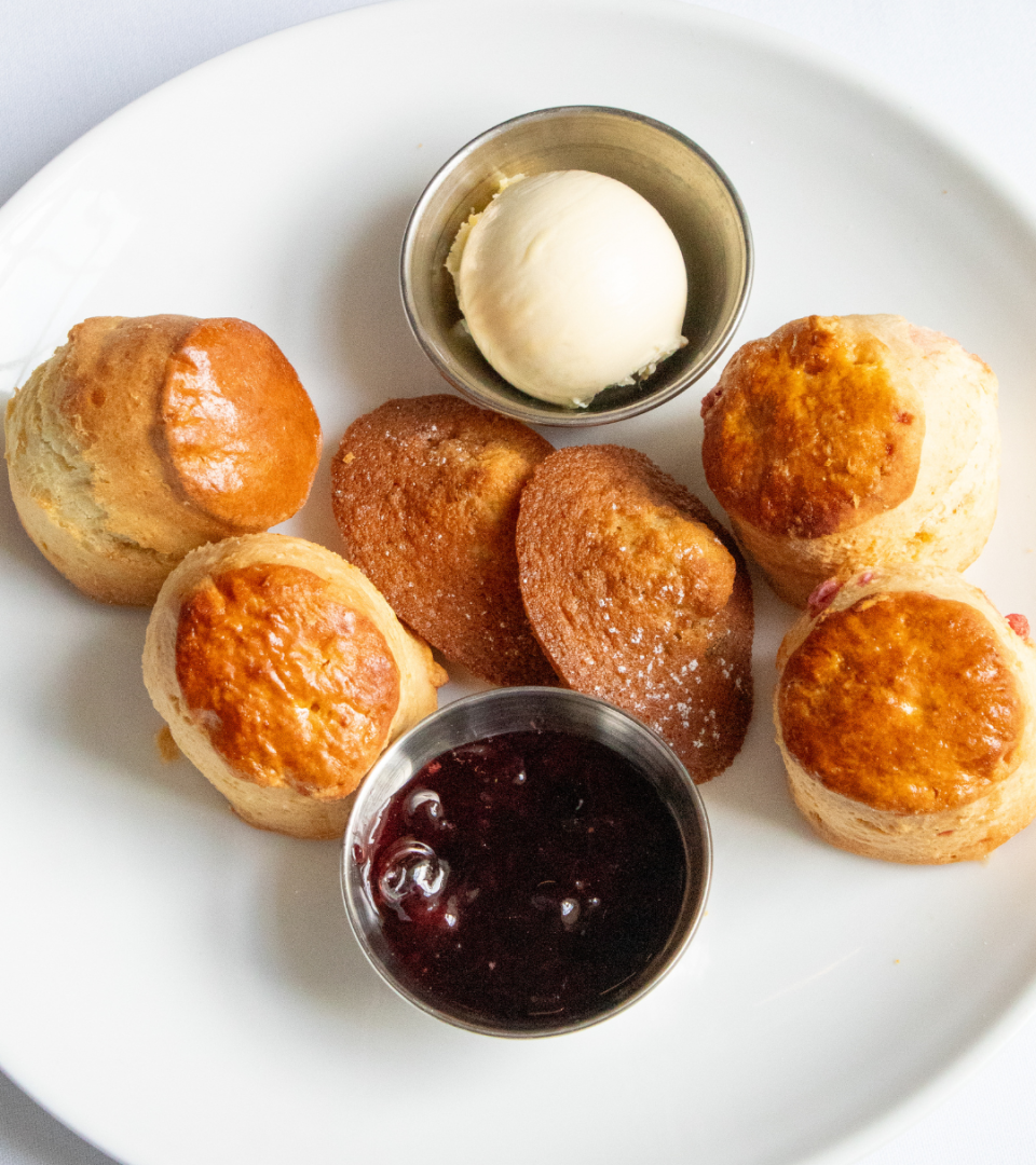 Plate of freshly baked plain and fruit scones served with clotted cream and strawberry jam as part of the Wimbledon-themed afternoon tea at Ness Walk.