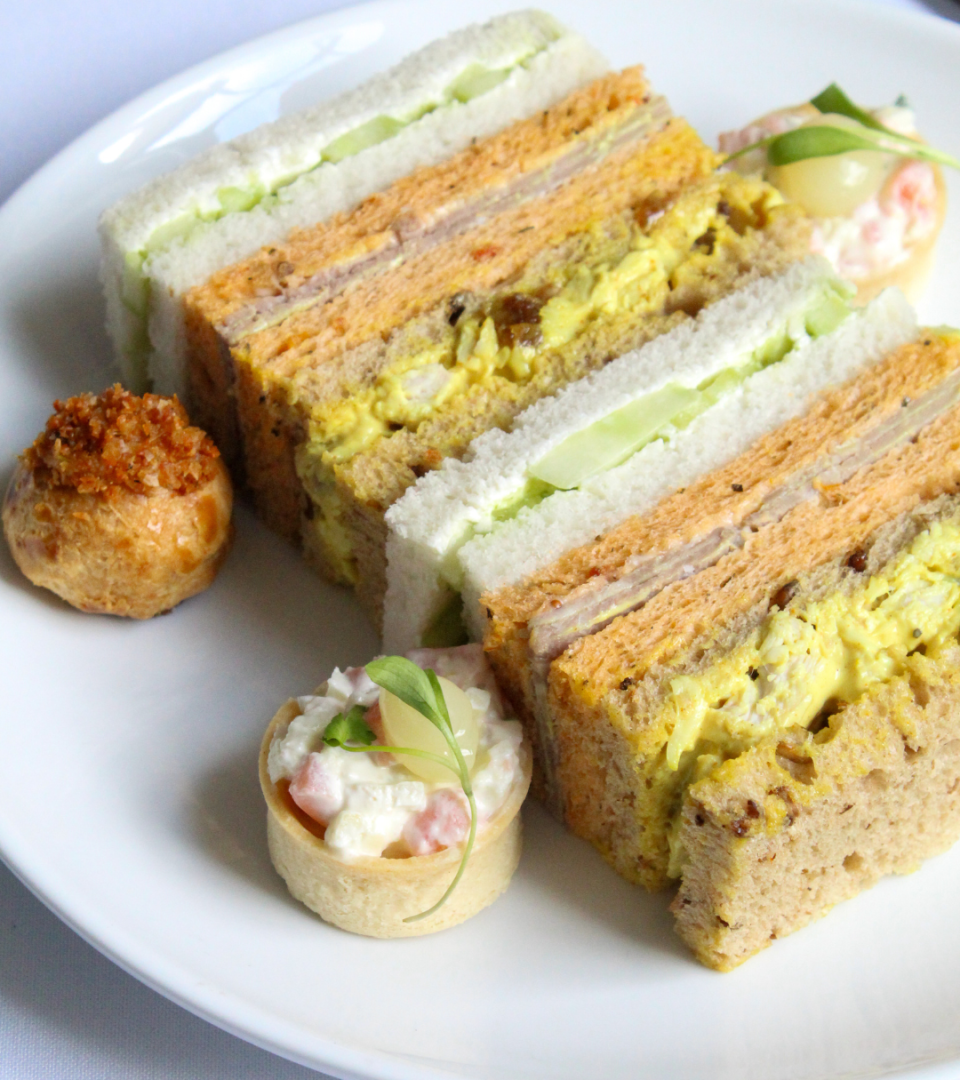 Selection of savoury finger sandwiches, mini tartlets, and bite-sized pastries served as part of the Wimbledon-themed afternoon tea experience at Ness Walk.