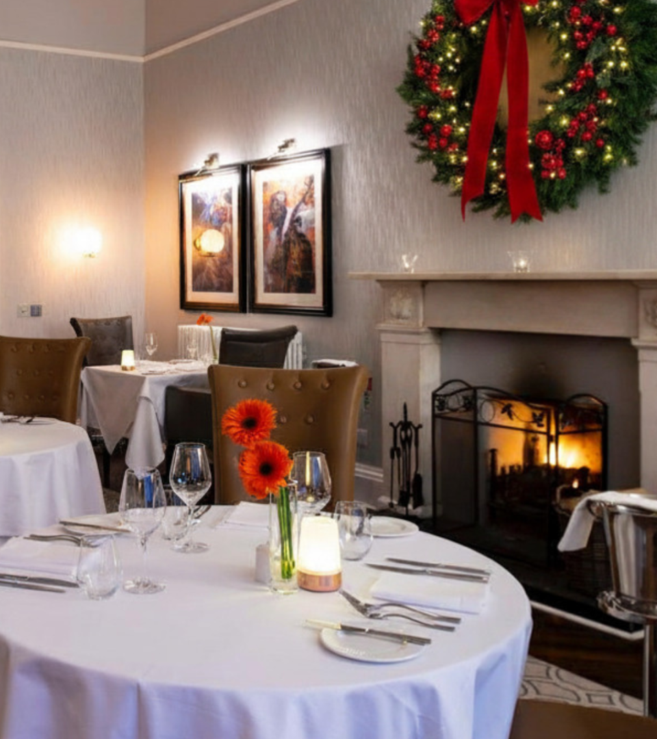 Torrish Restaurant set at Christmas time with a Christmas wreath Jung above a grand fireplace.